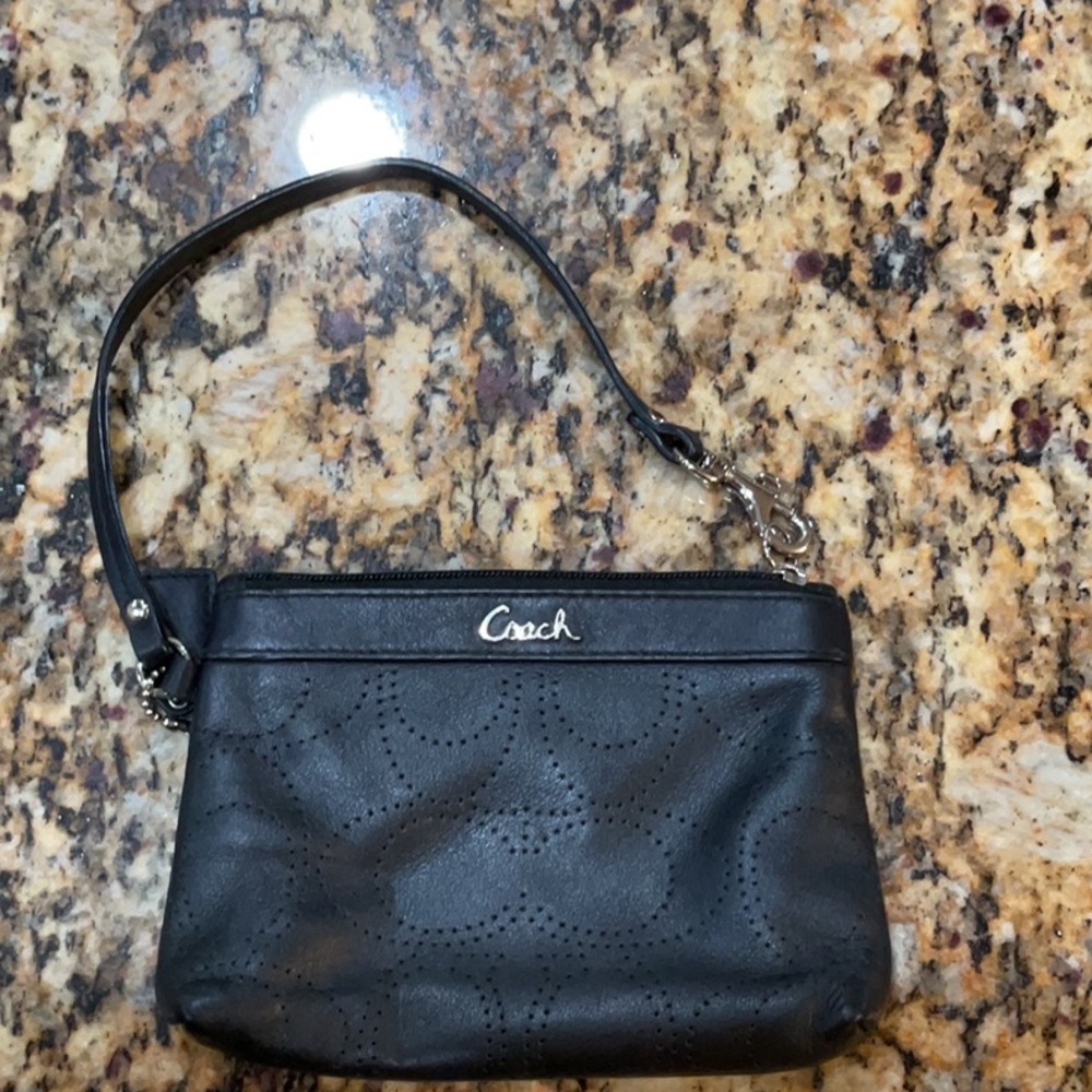 Like new Coach black wristlet perforated “C” logo with hangtag.